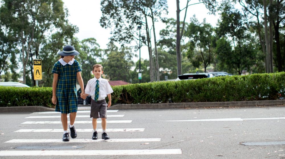 two students walking across crossing